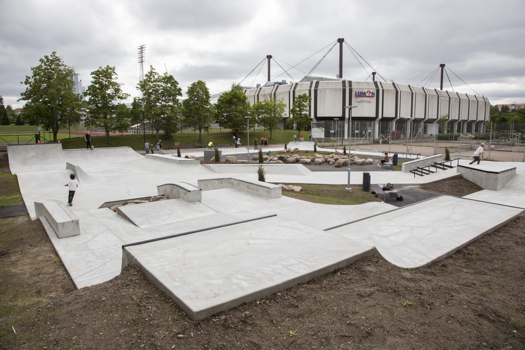 Urheilupuiston skeittiparkki. Betonista muotoiltuja ramppeja. Taustalla Kouvolan jäähalli.