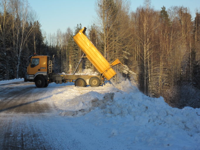 Kuorma-auto kippaa lumikuorman lumenkaatopaikalle.