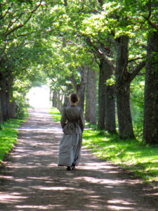 Nainen kävelee puistokujaa pitkin. Mainoskuva Ankkapurhan kummituskävelyä varten.