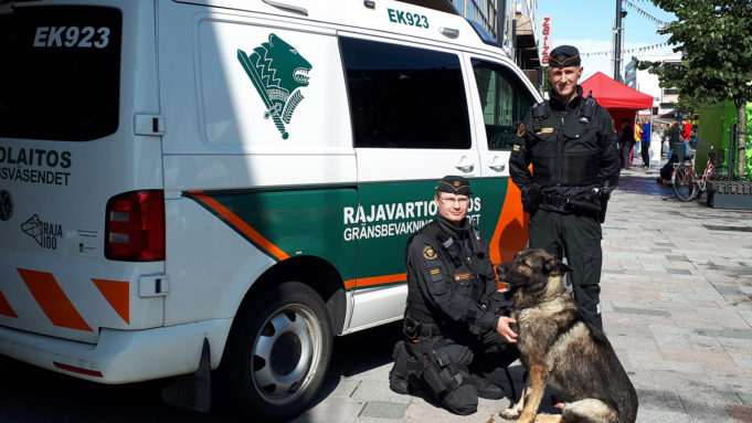 Rajavartiolaitoksen auto, koiranohjaaja ja koira esittelyssä Manskilla.