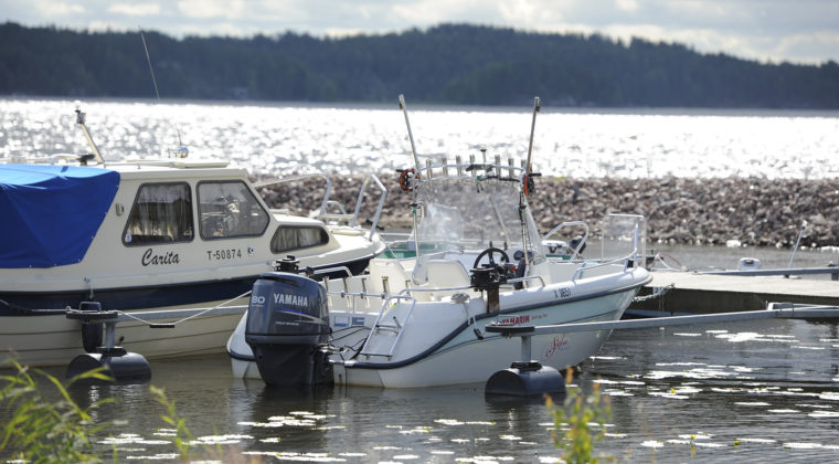 Valkoisia moottoriveneitä Jaalassa järven rannalla..