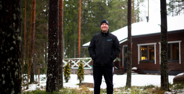 Patrik Lehto seisoo metsässä ja hymyilee.