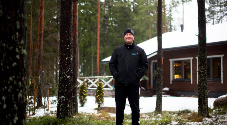 Patrik Lehto seisoo metsässä ja hymyilee.