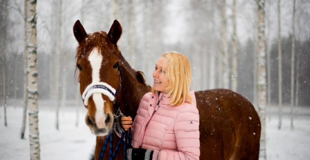 Päivi Kähkönen lumisateessa hevonsensa kanssa