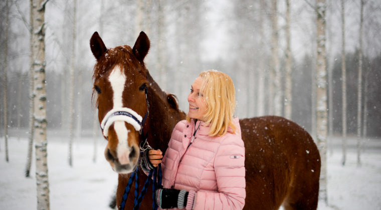 Päivi Kähkönen lumisateessa hevonsensa kanssa