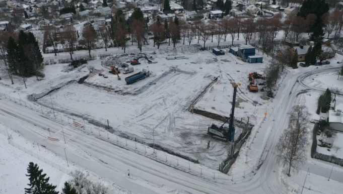 Ilmakuva Sarkolan koulun työmaalta. Luminen maisema, työkoneita työmaalla.