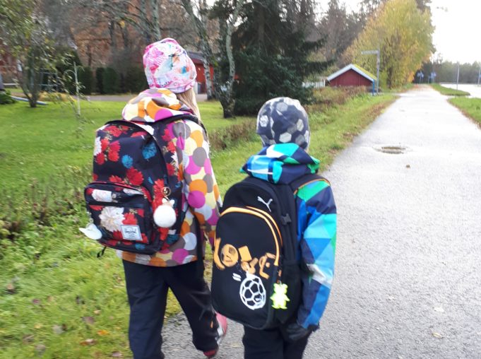 tyttö ja poika kävelemässä koulureput selässä