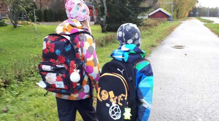 tyttö ja poika kävelemässä koulureput selässä