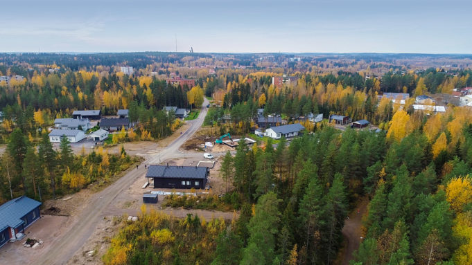 Valmiita ja rakenteilla olevia omakotitaloja Lohitien varrella. Ilmakuva. Metsää ympärillä.