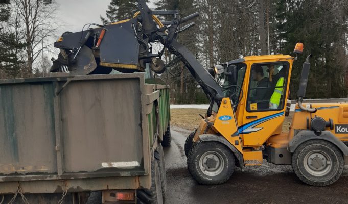 Hiekanharjauskone tyhjentää hiekkasäiliötä lavalle.