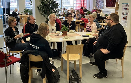 Pointin avajaisissa ihmisiä pöydän äärellä.