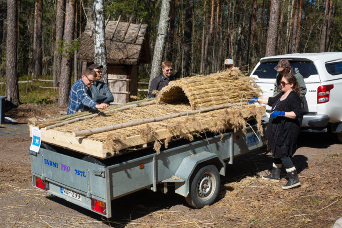 Järviruo'osta rakennettu lintujen pesimälauttaa peräkärrin päällä. Kuusi henkilöä ympärillä.