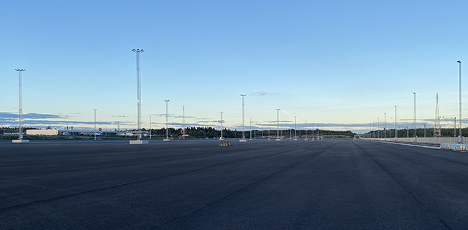 Asfalttikenttä, jolla pystyssä useita korkeita valaisinmastoja.