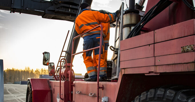 Men working with a container crane.