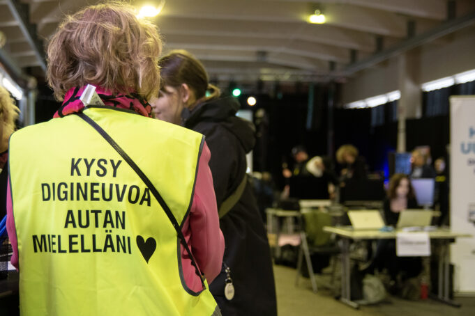 Digiopastaja opastaa keltainen huomioliivi päällä.