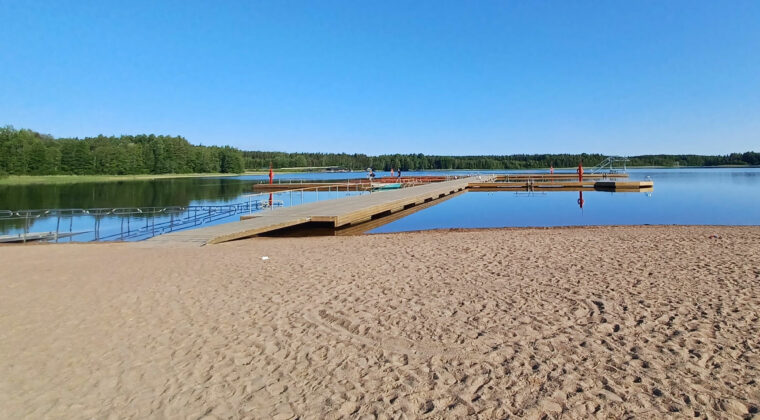 Käyrälammen uimarannan laituri, jolla pari ihmistä.