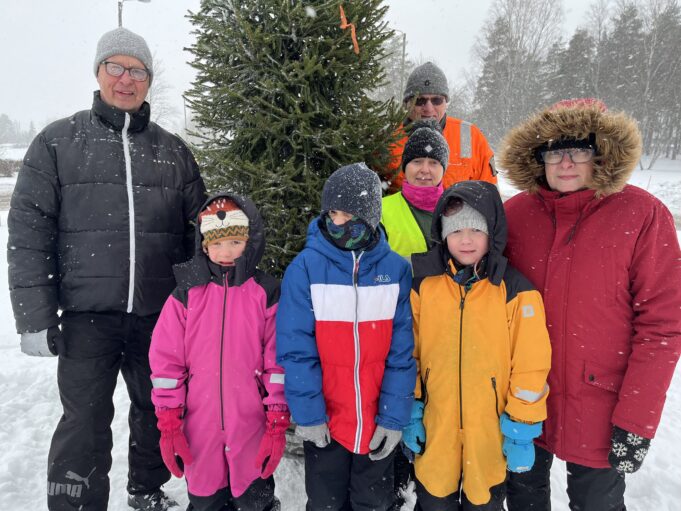 Ihmisiä pystyttämässä ja koristelemassa joulukuusta Keltakankaan kiertoliittymässä 22.12.2023.