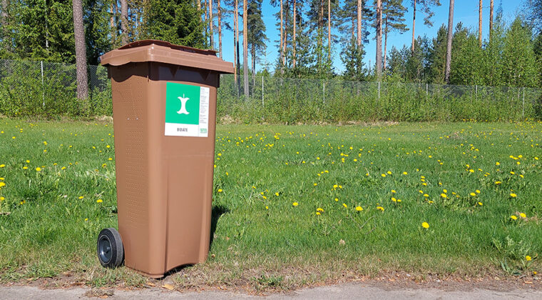 Ruskea biojäteastia nurmikolla