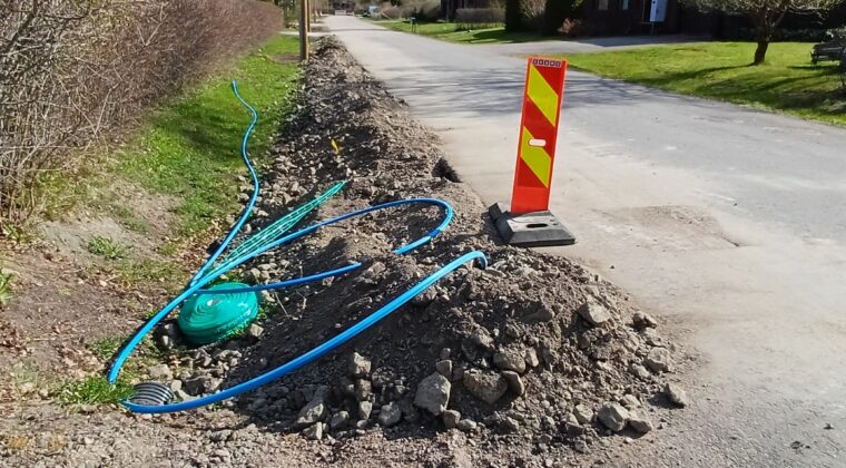 Ojassa hiekalla täytetty kaivanto, jonka päällä kaapelia.