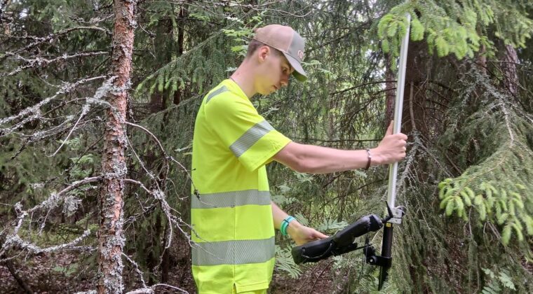 Huomioasuinen mies tarkistuslaitteiston kanssa metsässä