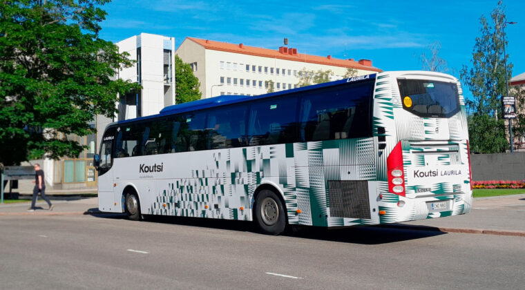 Linja-auto, jossa on vihreä-valkoinen teippaus.