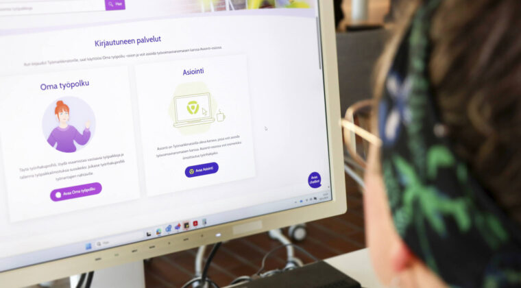 Henkilö katsoo tietokoneen ruutua.