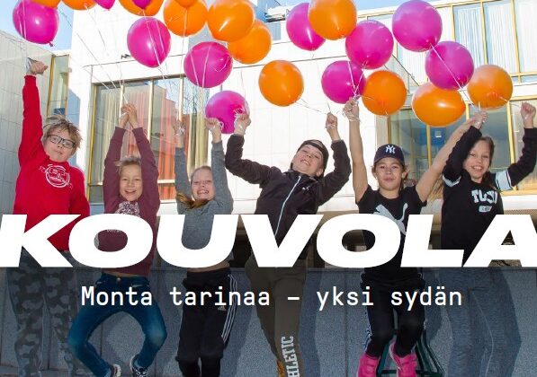 Lapset hyppäävät ilmaan Kouvolan kaupungintalon edessä punaoranssien ilmapallojen kanssa.