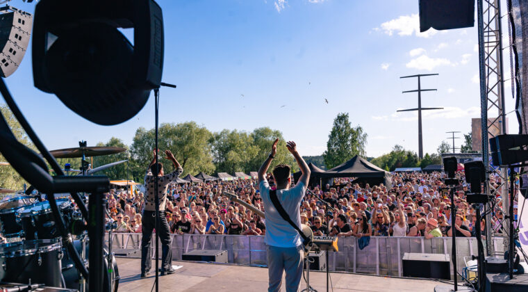 Artisti esiintymässä lavalla Wiinijuhlissa. Kuvattu lavaltapäin kohti yleisöä.