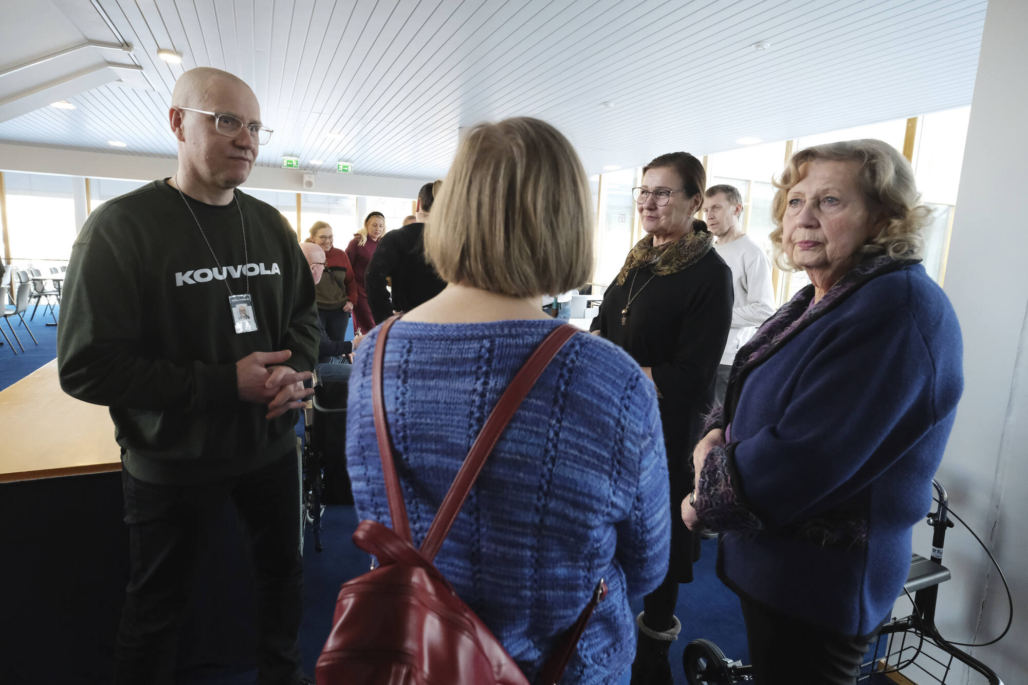 Ryhmä ihmisiä keskustelemassa tilassa, jossa tapahtuma menossa.