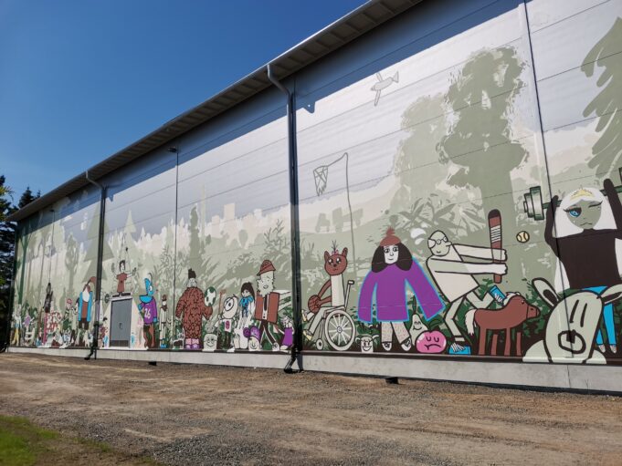 Kuvassa on seinä, johon on maalattu erilaisia kuvitteellisia ihmishahmoja