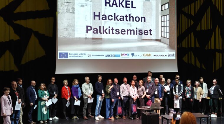 Kaikki Hackathonin osallistujat lavalla Kuusankoskitalolla.