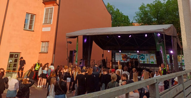 Nuoria ihmisiä lavan edessä Nuorten Paikan sisäpihalla.