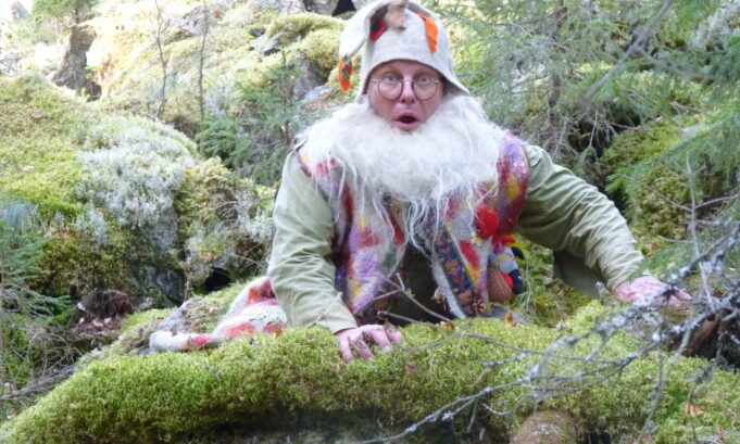 Tonttu-hahmo metsässä sammaleen päällä